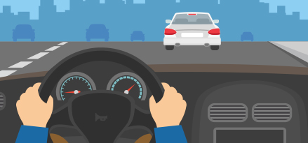 En person som kör en bil på vägen